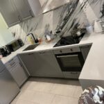 Столешница из искусственного камня с барной стойкой и опорой в пол на кухню изготовлено в правила камня