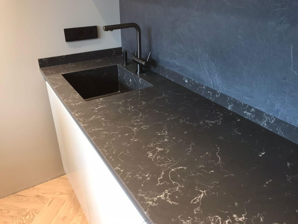 Столешница из кварцевого агломерата, мойка и пристенные плинтусы для кухни изготовлено в правила камня