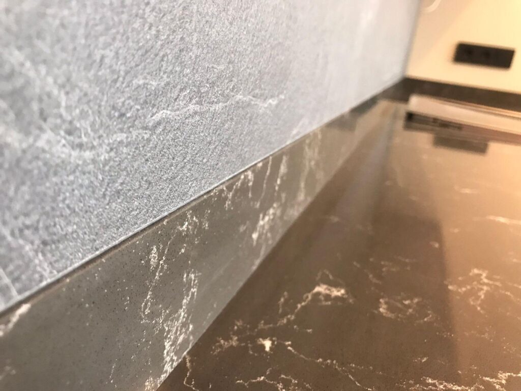 Столешница из кварцевого агломерата, мойка и пристенные плинтусы для кухни изготовлено в правила камня