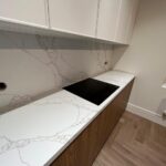 Угловая столешница и фартук из кварцевого агломерата изготовлено в правила камня