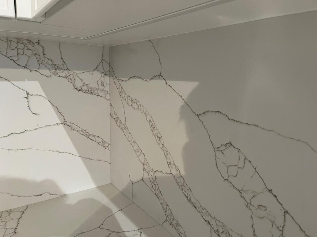 Угловая столешница и фартук из кварцевого агломерата изготовлено в правила камня