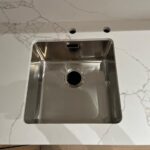 Угловая столешница и фартук из кварцевого агломерата изготовлено в правила камня