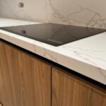 Угловая столешница и фартук из кварцевого агломерата изготовлено в правила камня