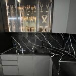 Угловая столешница, фартук и барная стойка из темного кварцевого агломерата изготовлено в правила камня