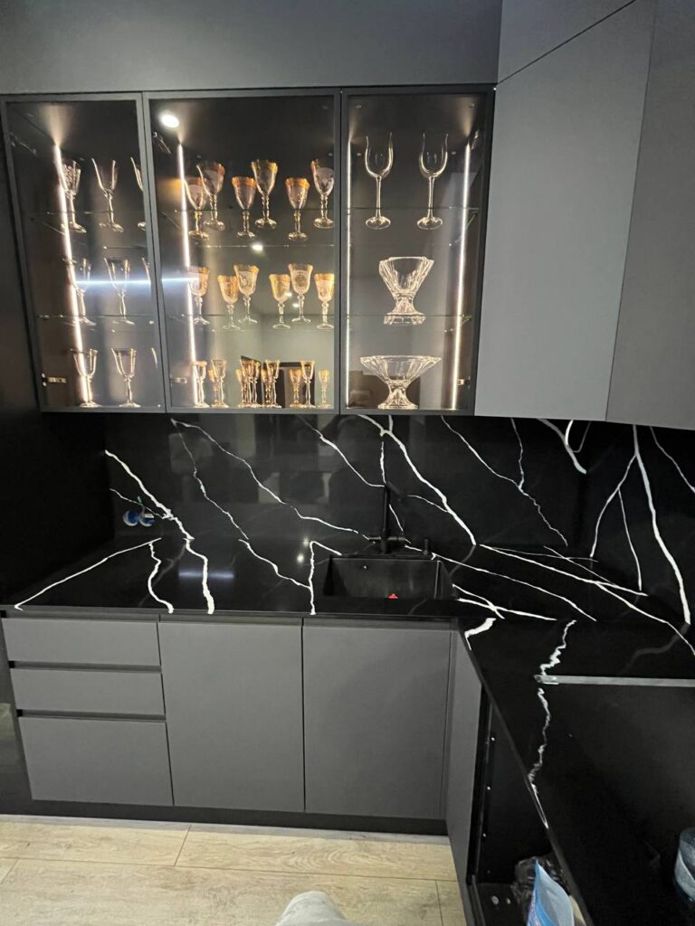 Угловая столешница, фартук и барная стойка из темного кварцевого агломерата изготовлено в правила камня