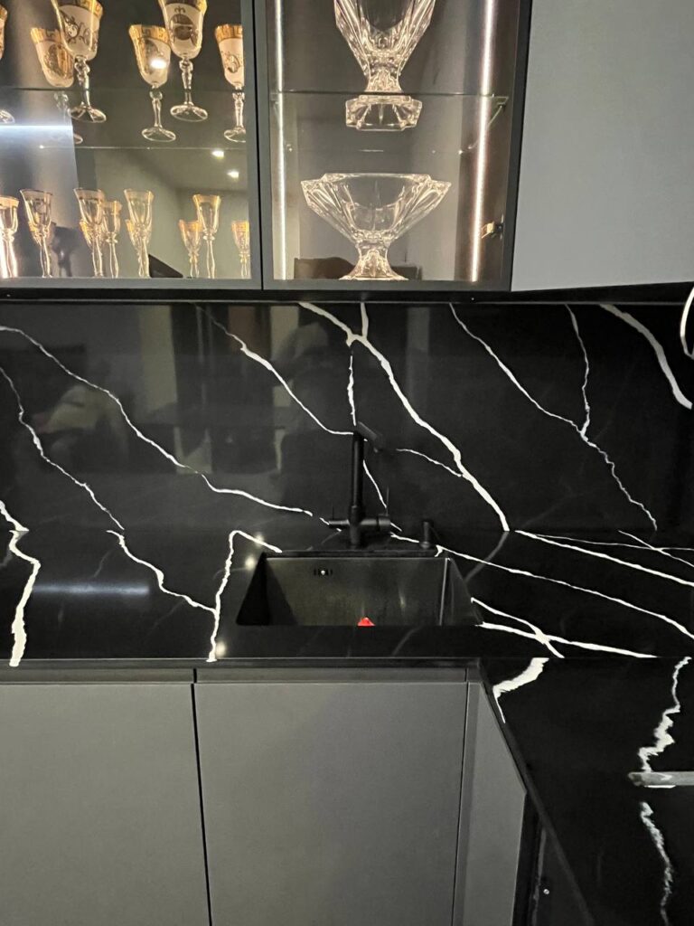 Угловая столешница, фартук и барная стойка из темного кварцевого агломерата изготовлено в правила камня