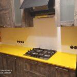 Желтая угловая столешница и мойка из искусственного камня изготовлено в правила камня