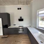 Бесшовная угловая столешница с мойкой и пристенным плинтусом на кухню из искусственного камня изготовлено в правила камня