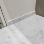 Столешница для кухни из искусственного камня с пристенным плинтусом изготовлено в правила камня