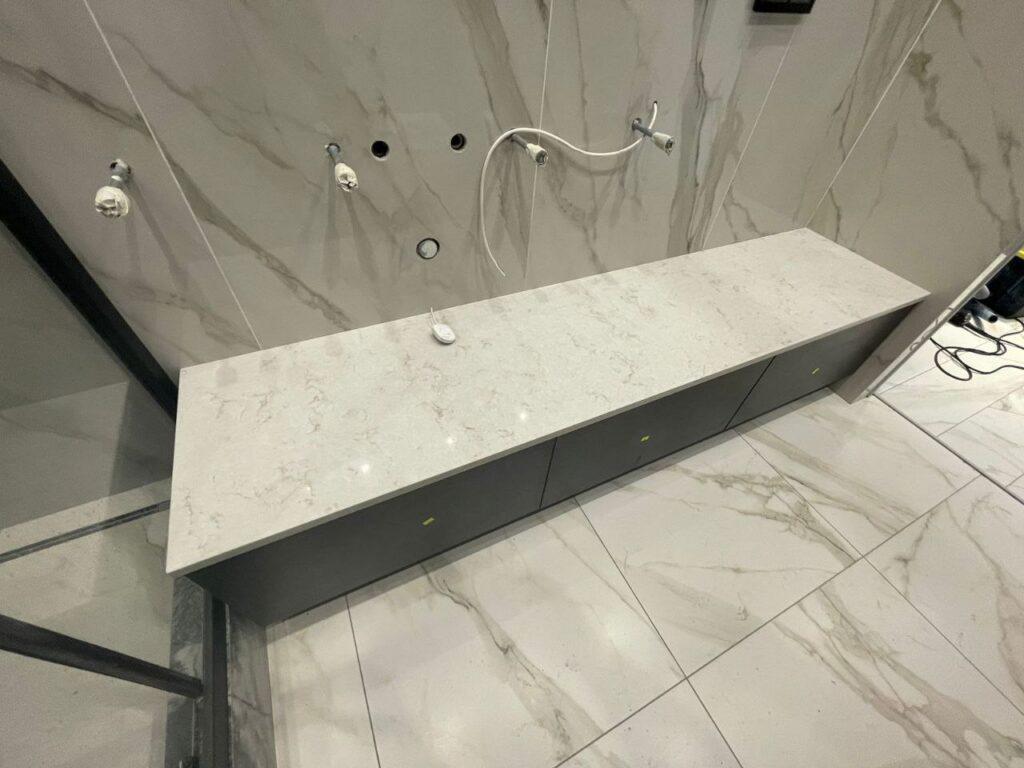 Столешница из кварцевого агломерата в ванную комнату изготовлено в правила камня