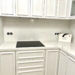 Угловая столешница и фартук из светлого искусственного камня изготовлено в правила камня