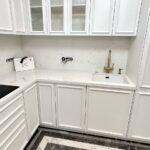 Угловая столешница и фартук из светлого искусственного камня изготовлено в правила камня