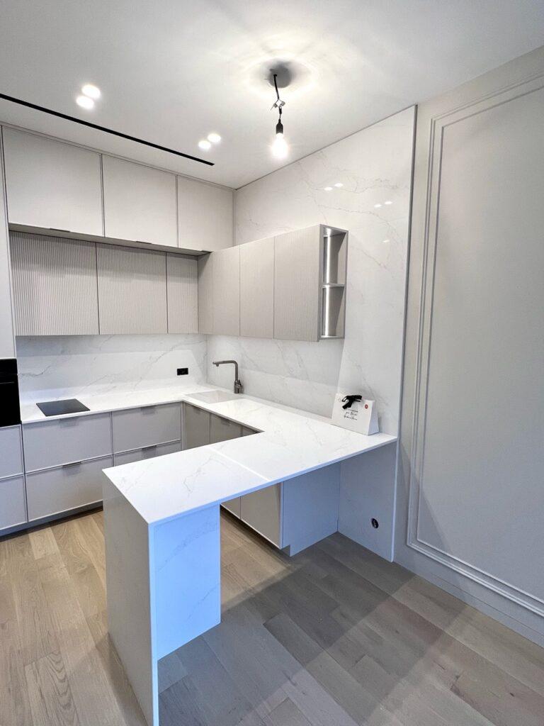 Кухонная столешница, мойка, стеновая панель и барная стойка из белого кварцевого агломерата изготовлено в правила камня