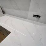 Кухонная столешница, мойка, стеновая панель и барная стойка из белого кварцевого агломерата изготовлено в правила камня