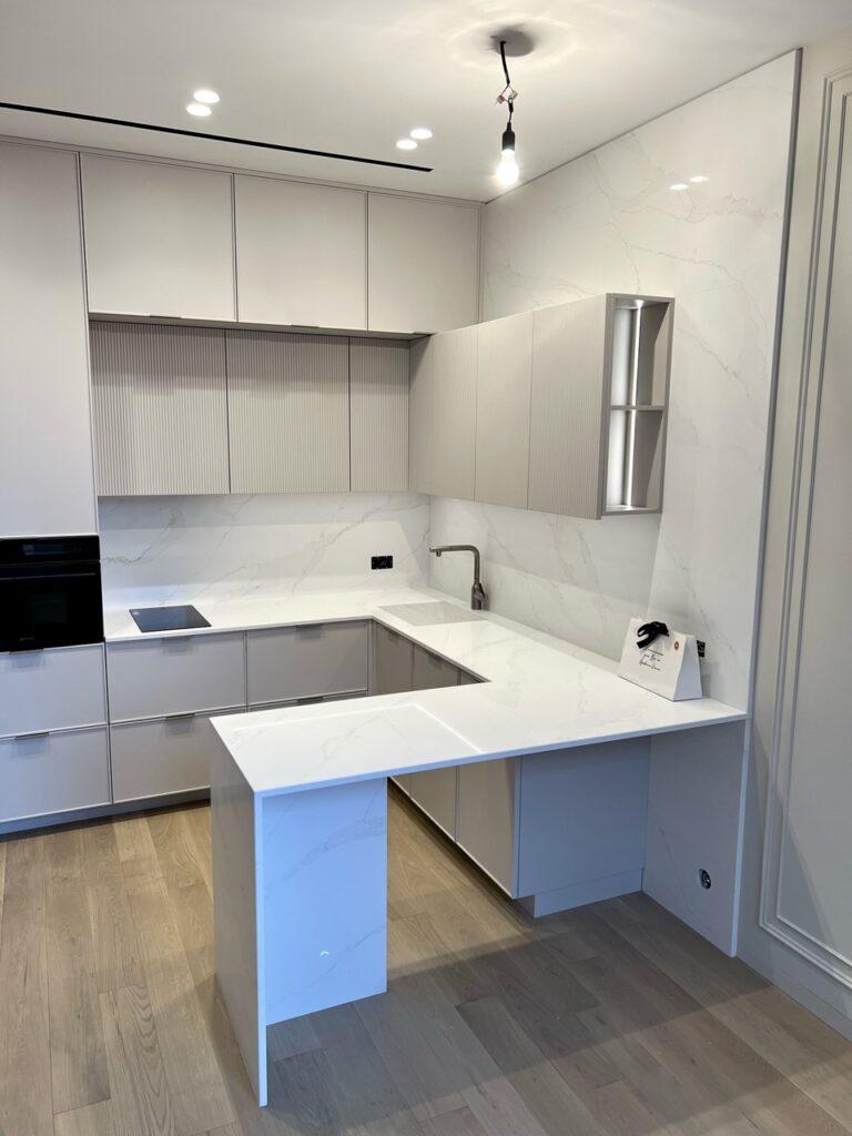 Кухонная столешница, мойка, стеновая панель и барная стойка из белого кварцевого агломерата изготовлено в правила камня